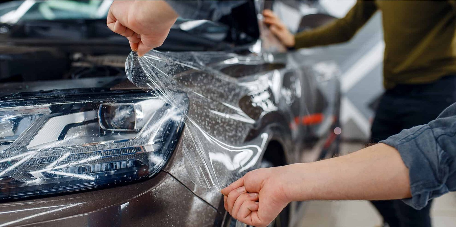 worker-applies-car-protection-film-on-front-fender-2024-11-29-18-40-02-utc